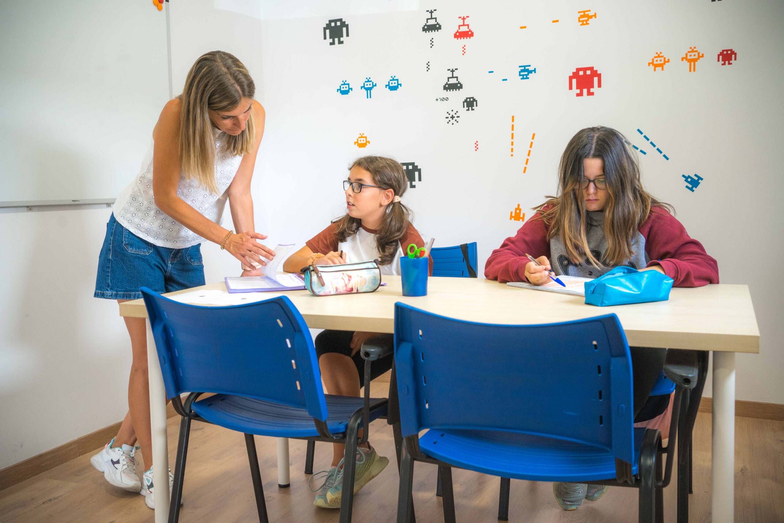 profesora imparte clase a dos alumnas